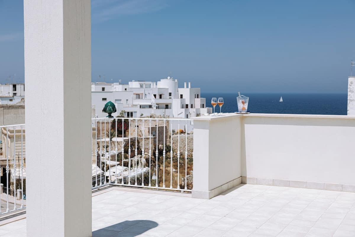 Un balcó amb vista al mar i edificis blancs.