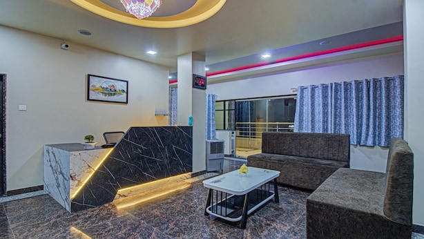A modern lobby with a marble reception desk, a sofa, and a coffee table. - Treebo Royal, Chandrapur (Chandrapur)