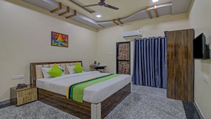 A hotel room with a bed, bedside table, and a TV. - Treebo Royal, Chandrapur (Chandrapur)