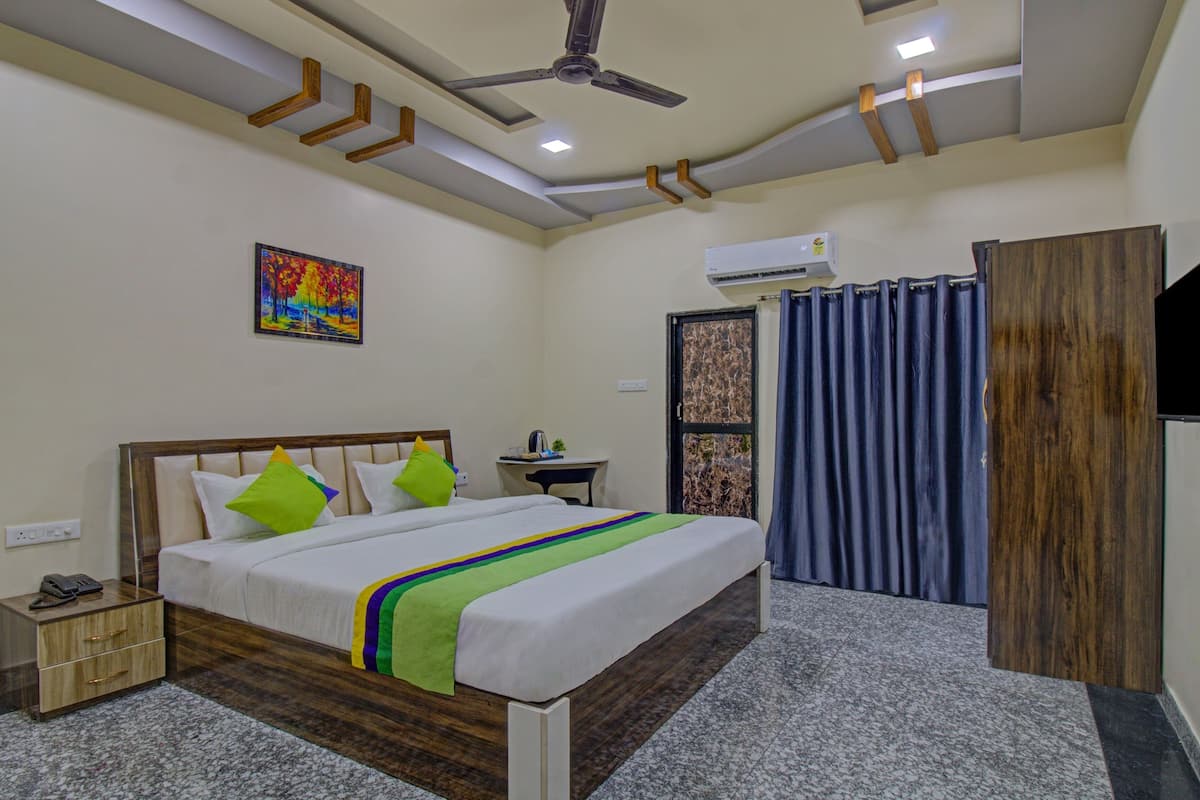 A hotel room with a bed, bedside table, and a TV.