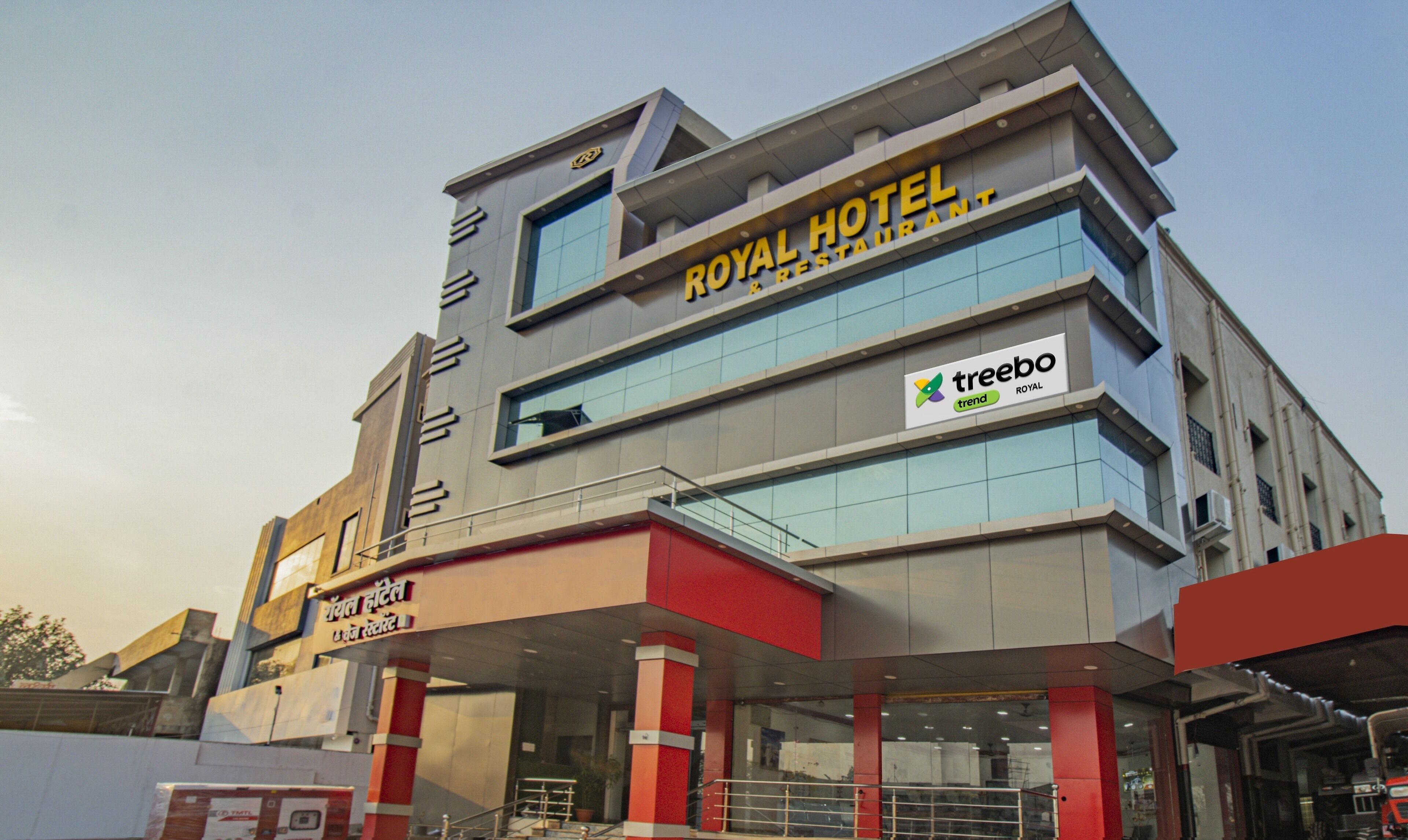 A hotel with a modern design, featuring a prominent sign for the Royal Hotel and a logo for Treebo.