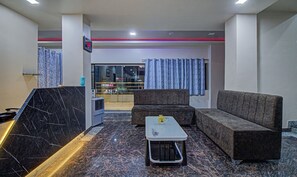 Una sala de estar moderna con piso de mármol, un sofá, una mesa de centro y un televisor.