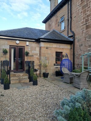 Stunning entrance with double doors, black gates, and a beautifully maintained garden.