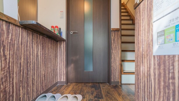 Eine Holztreppe führt zu einem Raum mit einer Tür.
