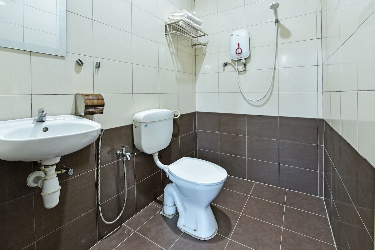 A bathroom with a white sink, a toilet, and a shower unit.
