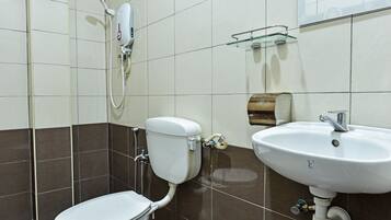 Un baño con inodoro, ducha y lavamanos.