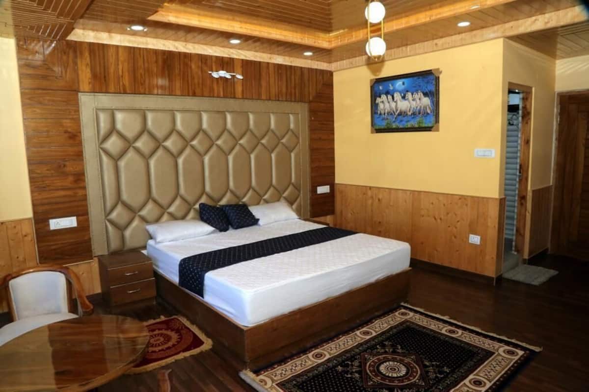 Ein Schlafzimmer mit einem großen Bett, einem Holzkopfende, einem Nachttisch, einem Sessel und einem Teppich.