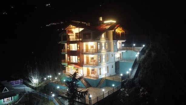 A multi-story hotel with a swimming pool and outdoor lighting. - Wood Crista Retreat by Park Tree (Theog)