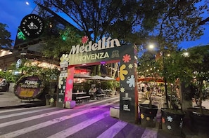 An outdoor dining area with a sign for 'Medellin Provence' and a flower-themed decoration.