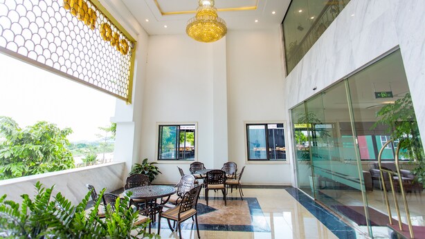 A modern indoor space with a high ceiling, a chandelier, and a seating area with tables and chairs. - Cao Minh Hotel Lao Cai (Lao Cai)