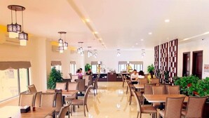 A spacious restaurant with multiple tables and chairs, a counter area, and a variety of hanging lights. - Cao Minh Hotel Lao Cai (Lao Cai)