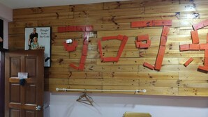 A room with a wooden wall, a wooden door, a wooden chair, and a wooden dresser. - Hotel O Coke Guest House (Alor Gajah)