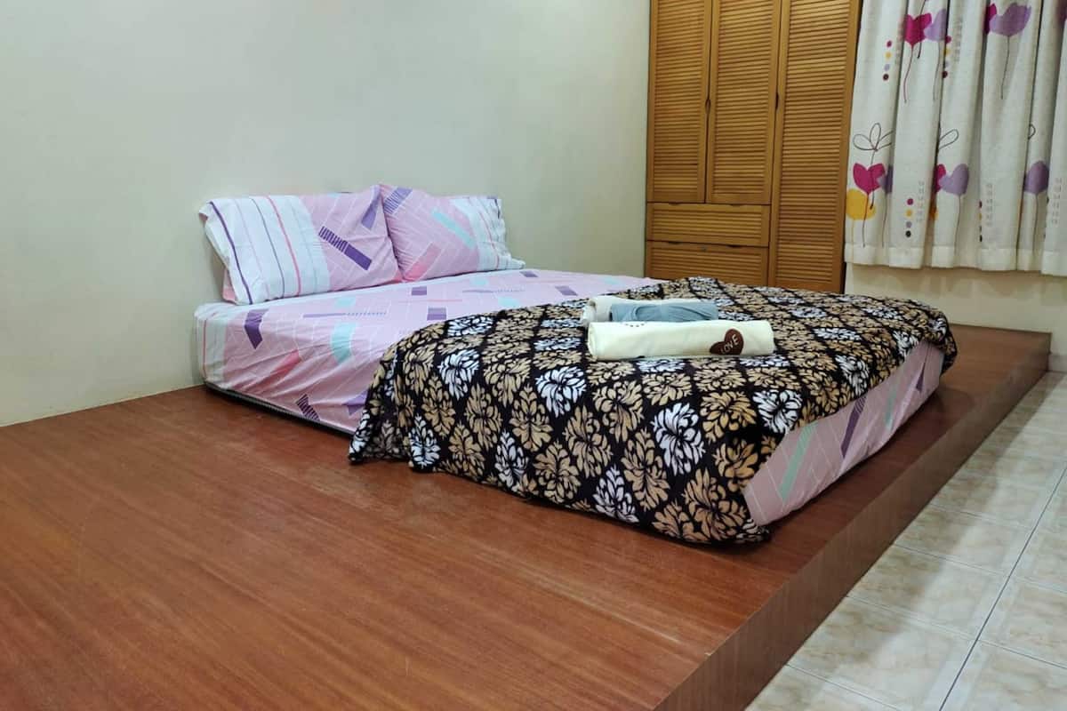 A bedroom with a bed, a wardrobe, and a curtain.