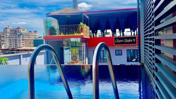 A swimming pool with metal railings, a restaurant named 'Bistro Rooftop' with outdoor seating, and a cityscape in the background. - Boun's Hotel Resort & Spa (Yaoundé)