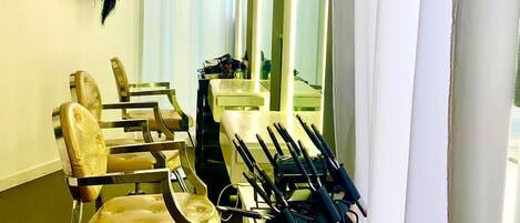 Un salón con varias sillas, espejos y estanterías llenas de productos.
