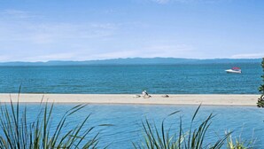 Ein Strand mit freiem Blick auf das Meer und ferne Berge.