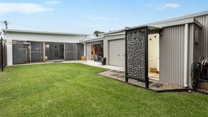 Ein Wohnhaus mit gepflegtem Rasen, überdachter Terrasse und Garage.