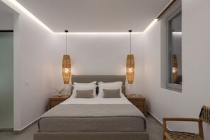 A modern bedroom with a bed, bedside tables, hanging lamps, and a window. - Villa Lefko a Cycladic escape in the heart of the Aegean (Μέγας Γιαλός)