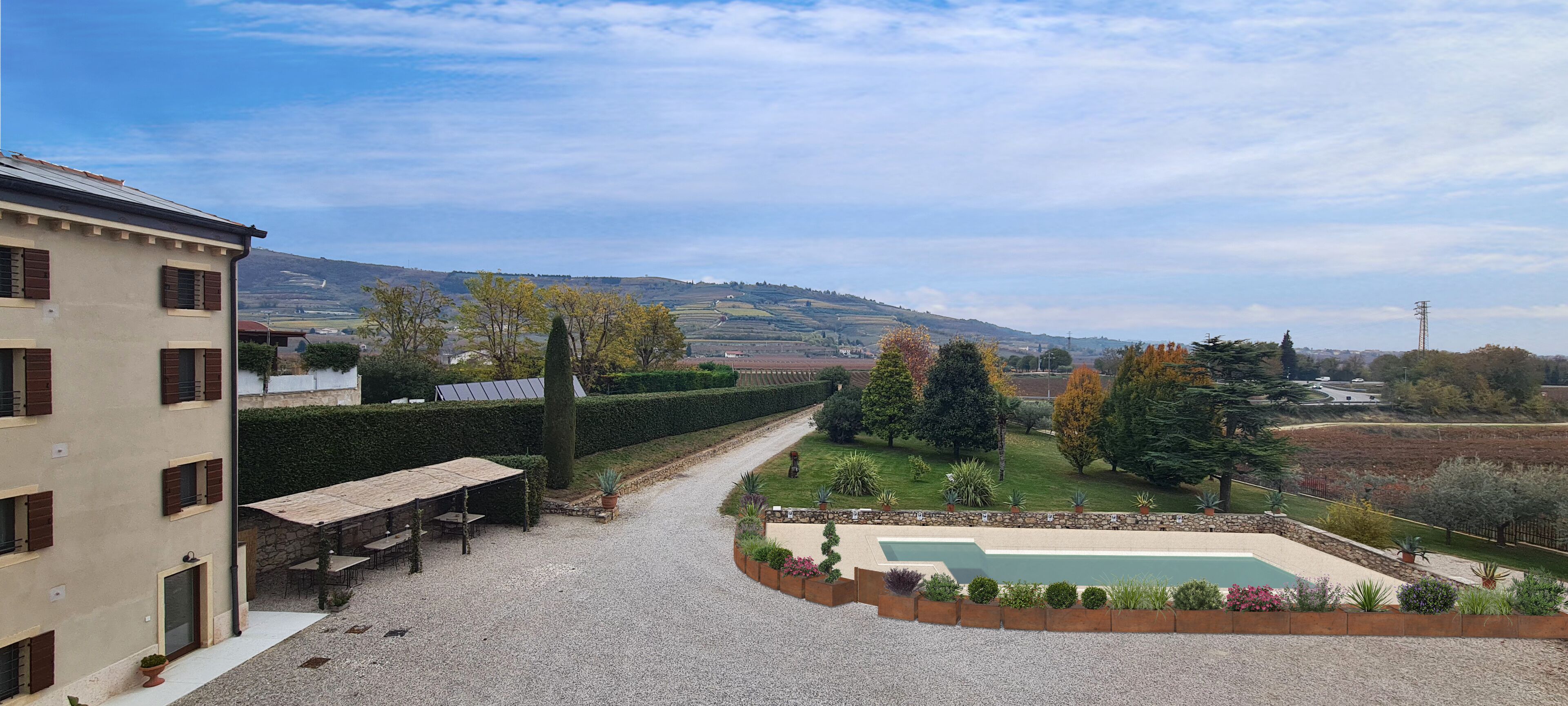 A courtyard with a pool, outdoor seating, and a view of the countryside.
