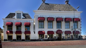 A hotel with red awnings and a sign reading "HOTEL RESTAURANT ZEEZICHT." - Logement Garjen (Harlingen)