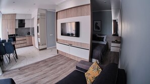 Een moderne woonruimte met een keuken, eetgedeelte en een slaapkamer.