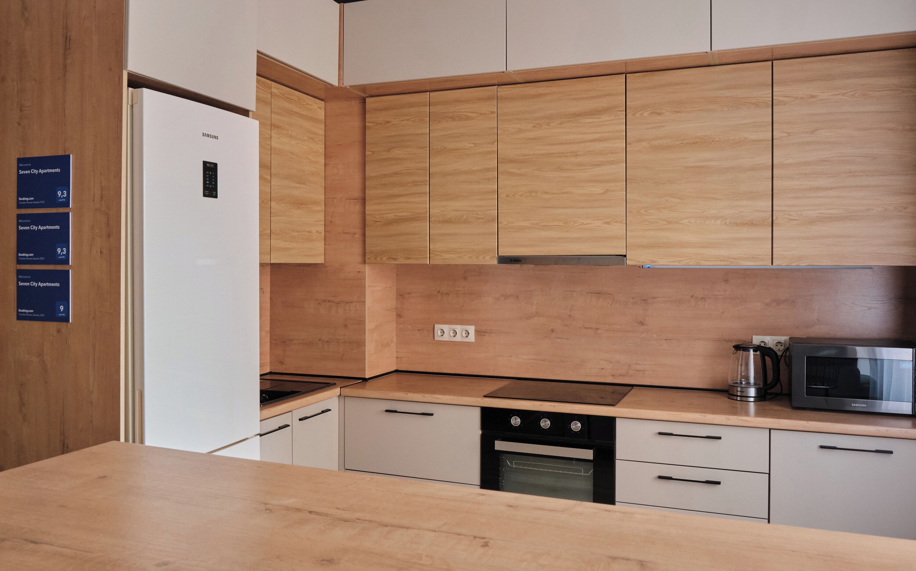 A modern kitchen with wooden cabinets, a built-in microwave, and a dishwasher.