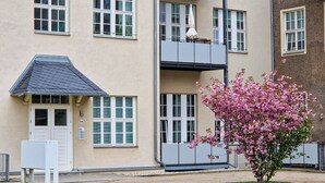 A multi-story building with a flat facade, large windows, and a small balcony.