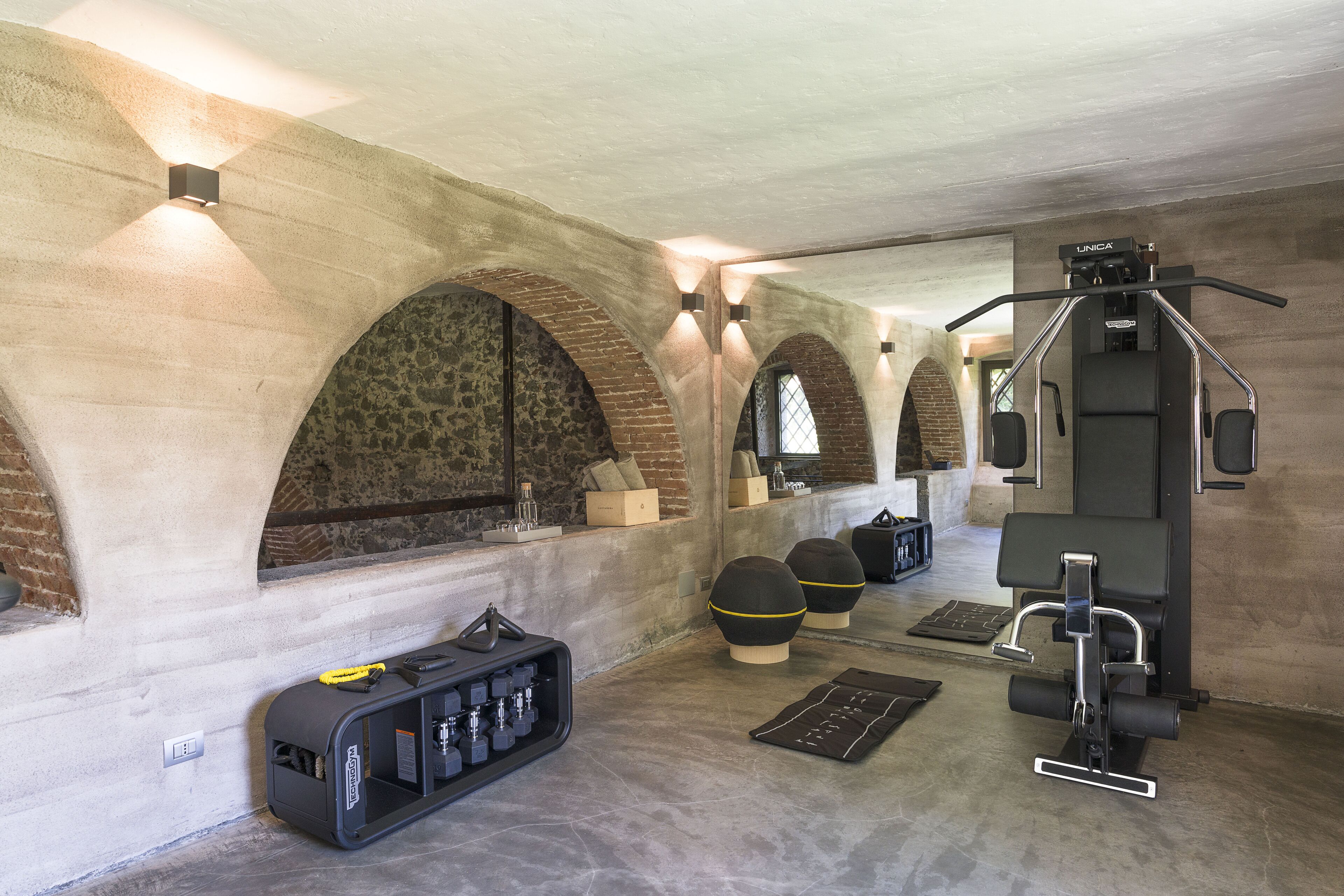 A gym with exercise equipment, a power tool case, and a mirror.