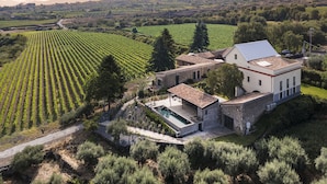 Una villa moderna con piscina, rodeada de viñedos.
