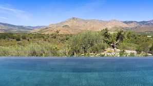 Una piscina cristalina con vistas a la montaña al fondo.