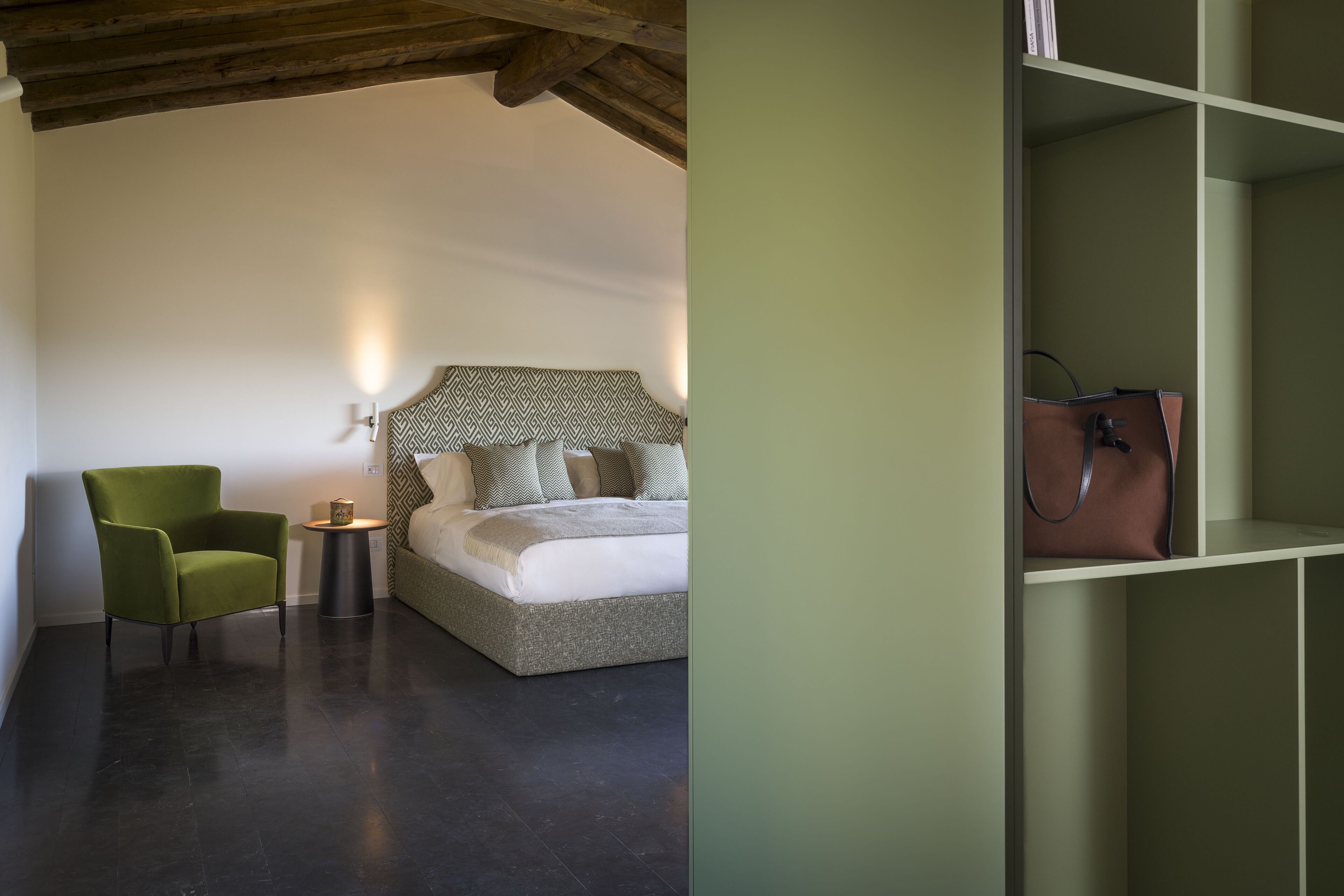 Une chambre à coucher comprenant un lit, une chaise, une table de chevet et une armoire.