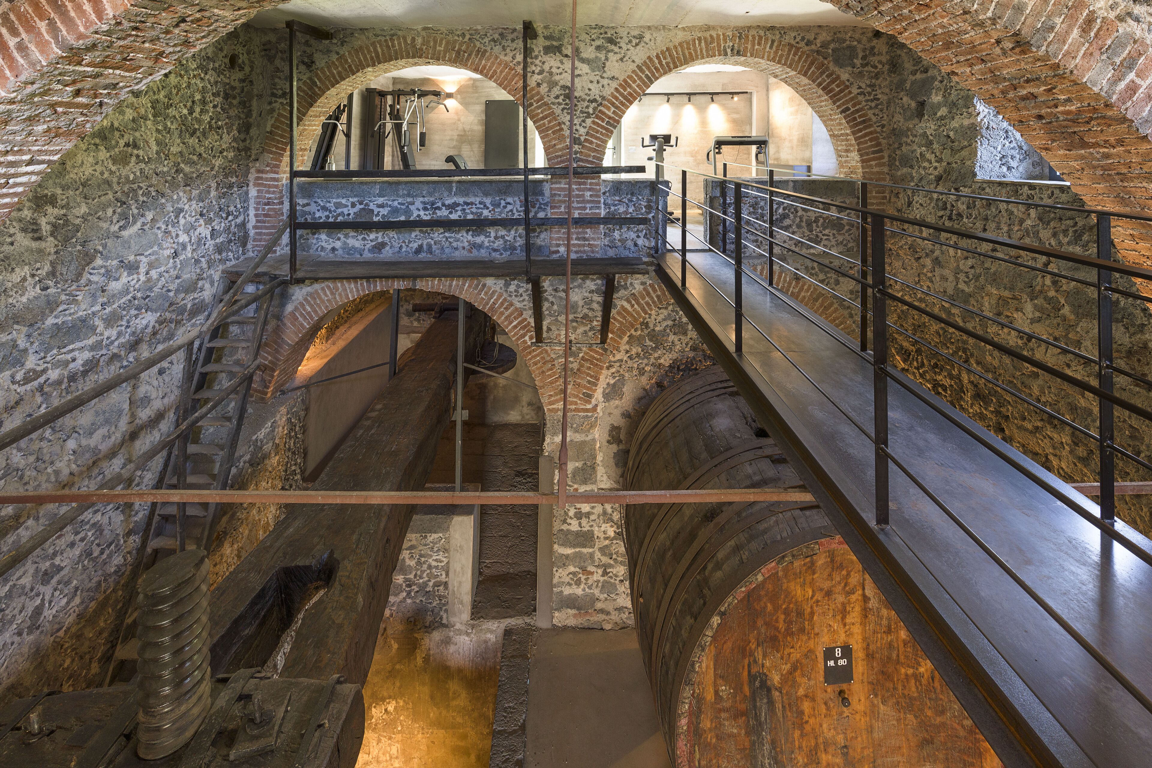 Un edificio histórico con arcos de piedra y una escalera de madera.