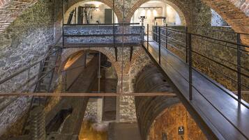 Un edificio histórico con arcos de piedra y una escalera de madera.