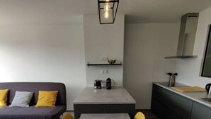 Una cocina moderna con una mesa de comedor, sillas amarillas y un sofá gris.