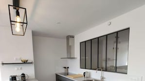 Una cocina moderna con una isla central, horno empotrado y un ventanal grande.
