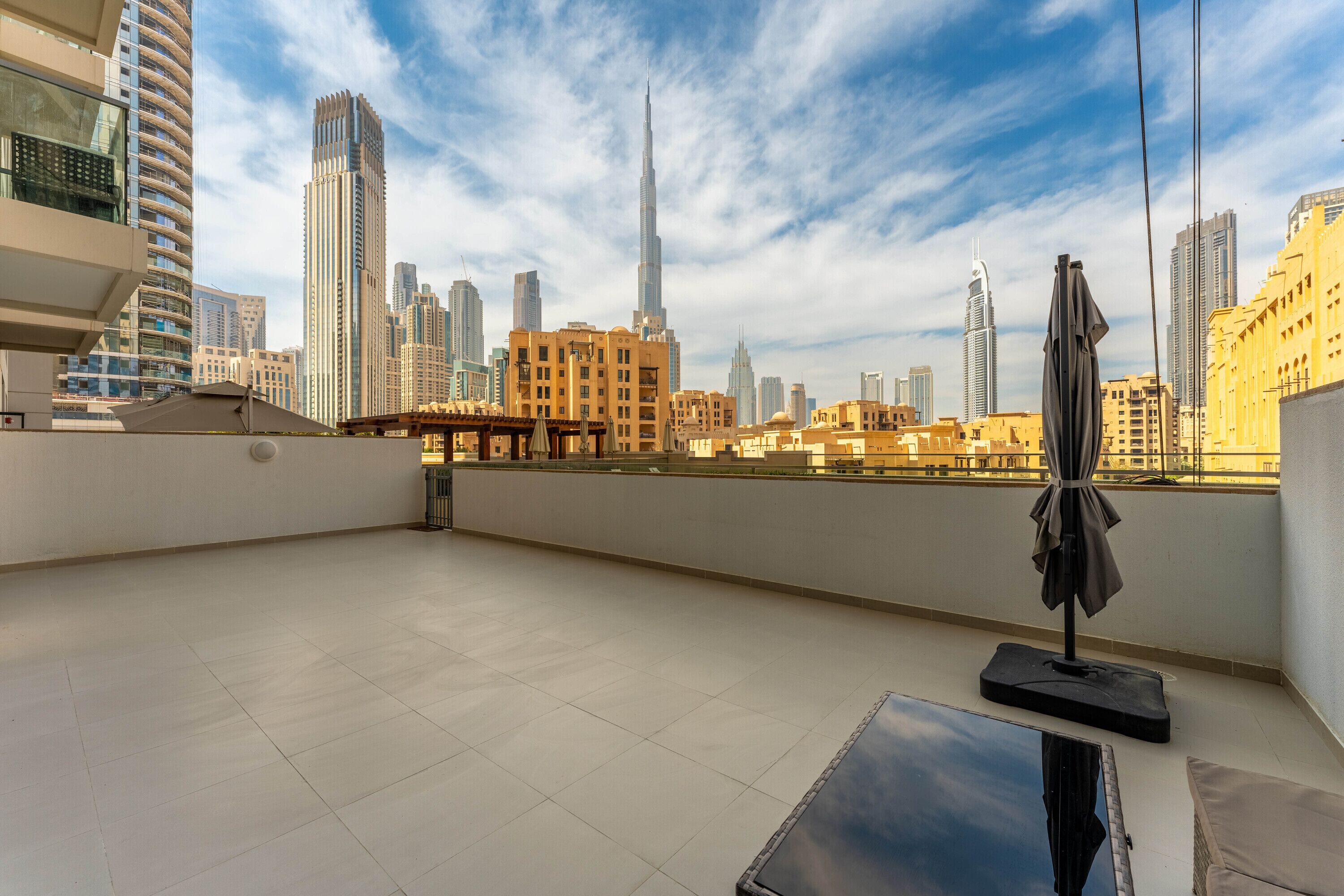 A rooftop terrace with a clear view of the city skyline, including tall buildings and a distinctive skyscraper.