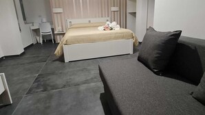 Une chambre à coucher moderne avec un lit, un canapé, un bureau et une chaise.