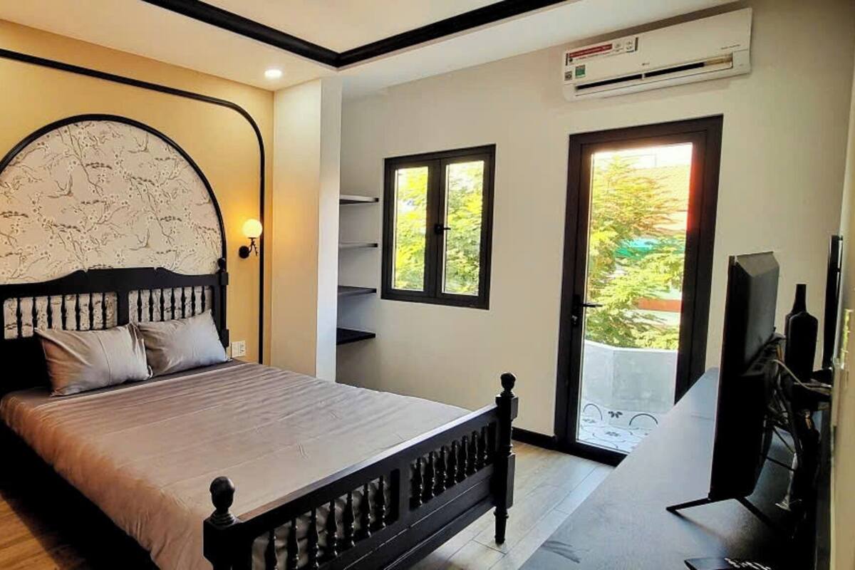 Quarto com cama, janela ampla e ar-condicionado.