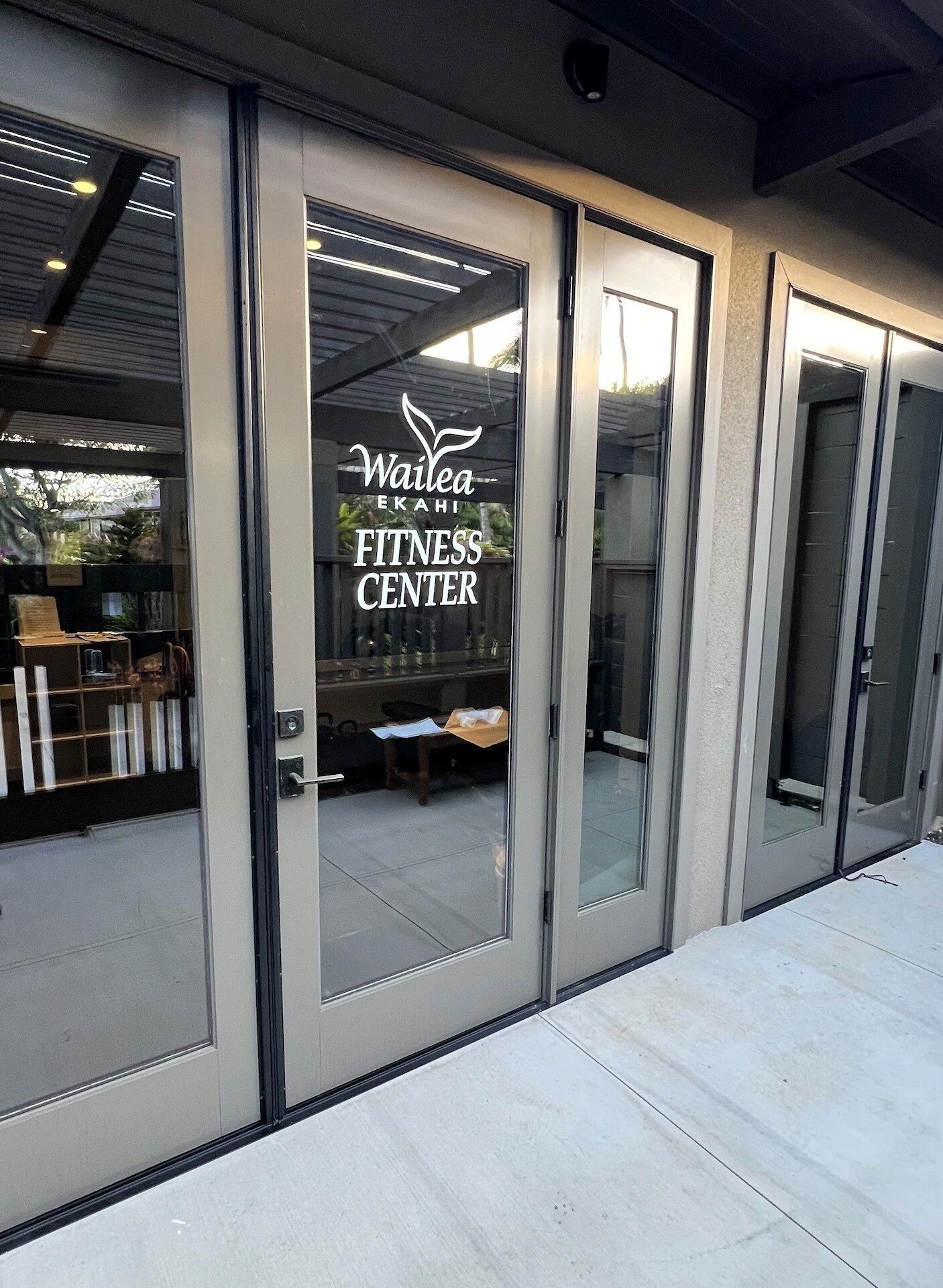 Un gimnasio con puertas de vidrio y un letrero que dice "Wailea Ekahi Fitness Center".