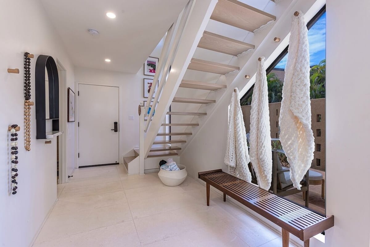 Ein modernes Interieur mit Treppe, Sitzbank und Blick ins Freie.