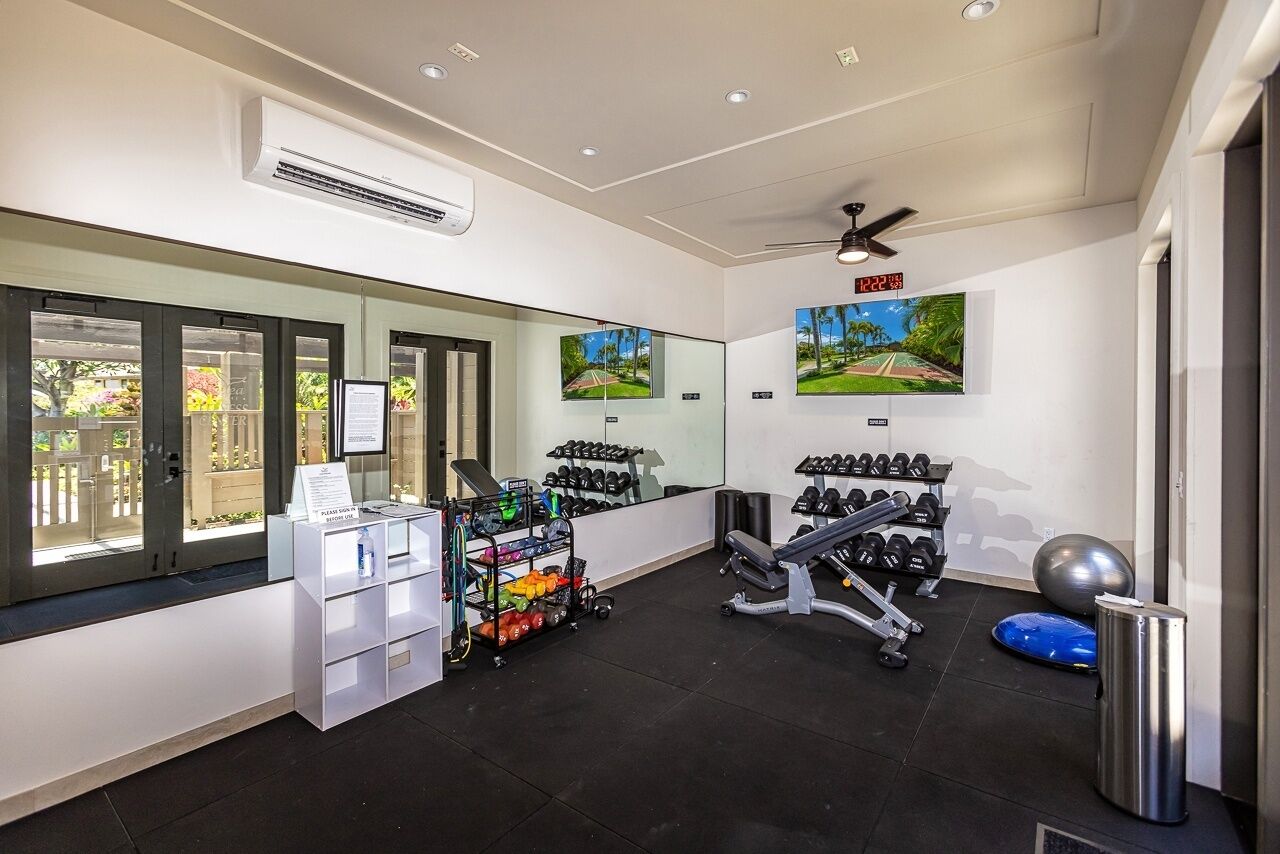 Un gimnasio con equipo de ejercicio, un espejo y un reloj digital.