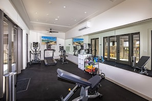 A modern gym with cardio equipment, weight machines, and a bench. - Wailea Ekahi Two Bedrooms - Ocean View by Coldwell Banker Island Vacations (Kihei)