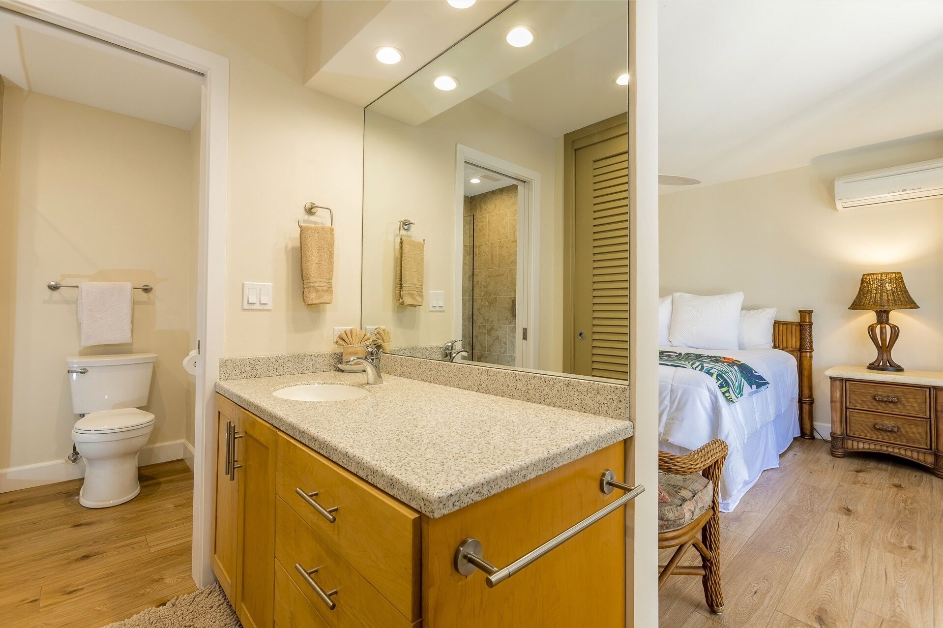 A bathroom with a sink, toilet, and mirror.