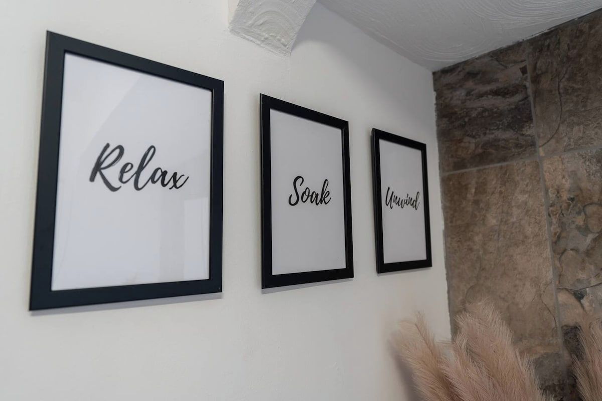 Three framed signs with the words 'Relax,' 'Soak,' and 'Wonderful' on a wall.