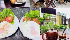 A dining area with a table set for two, a bottle of sauce, and a teapot. - Homestay Song Thien (Da Nang)