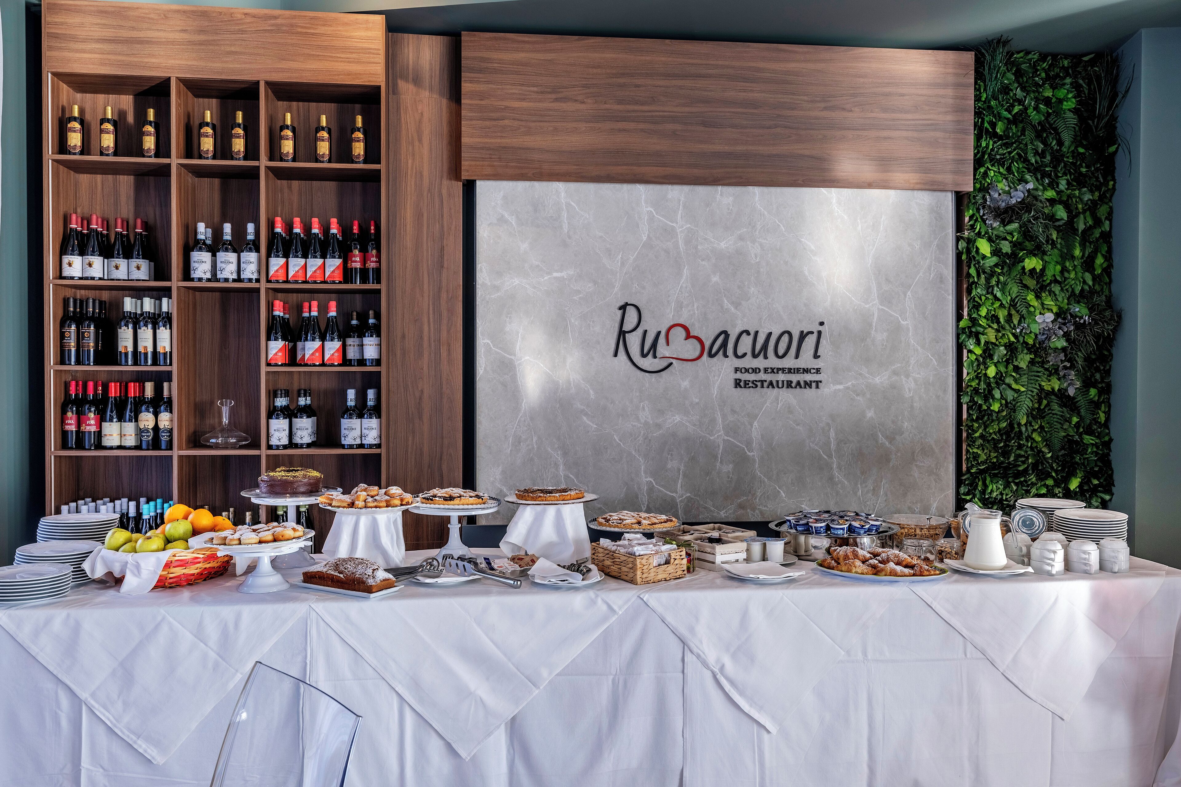 A buffet table with various food items and a wine selection.