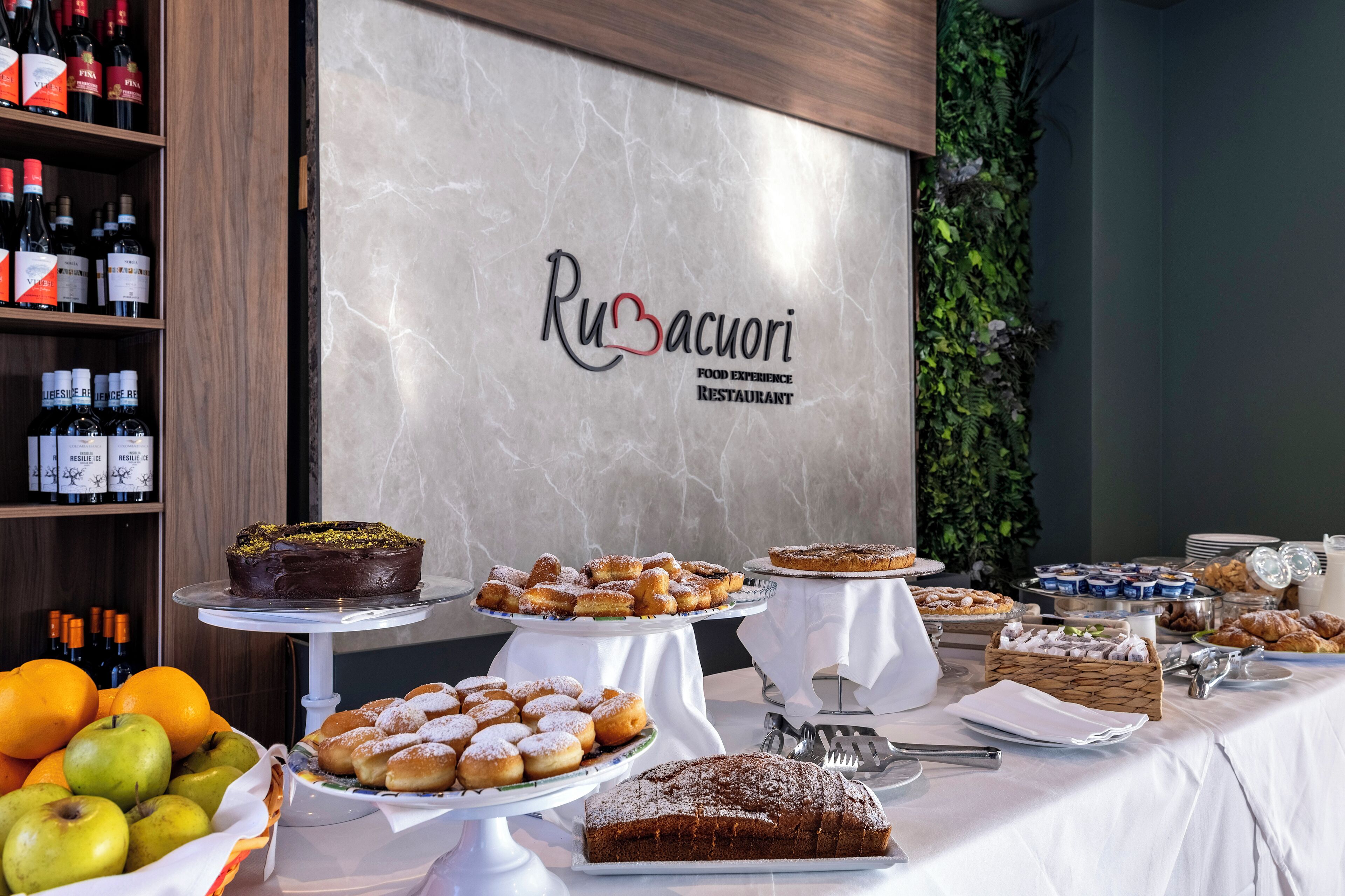 Un tavolo del buffet con diversi dolci, frutta e bevande in un ristorante.
