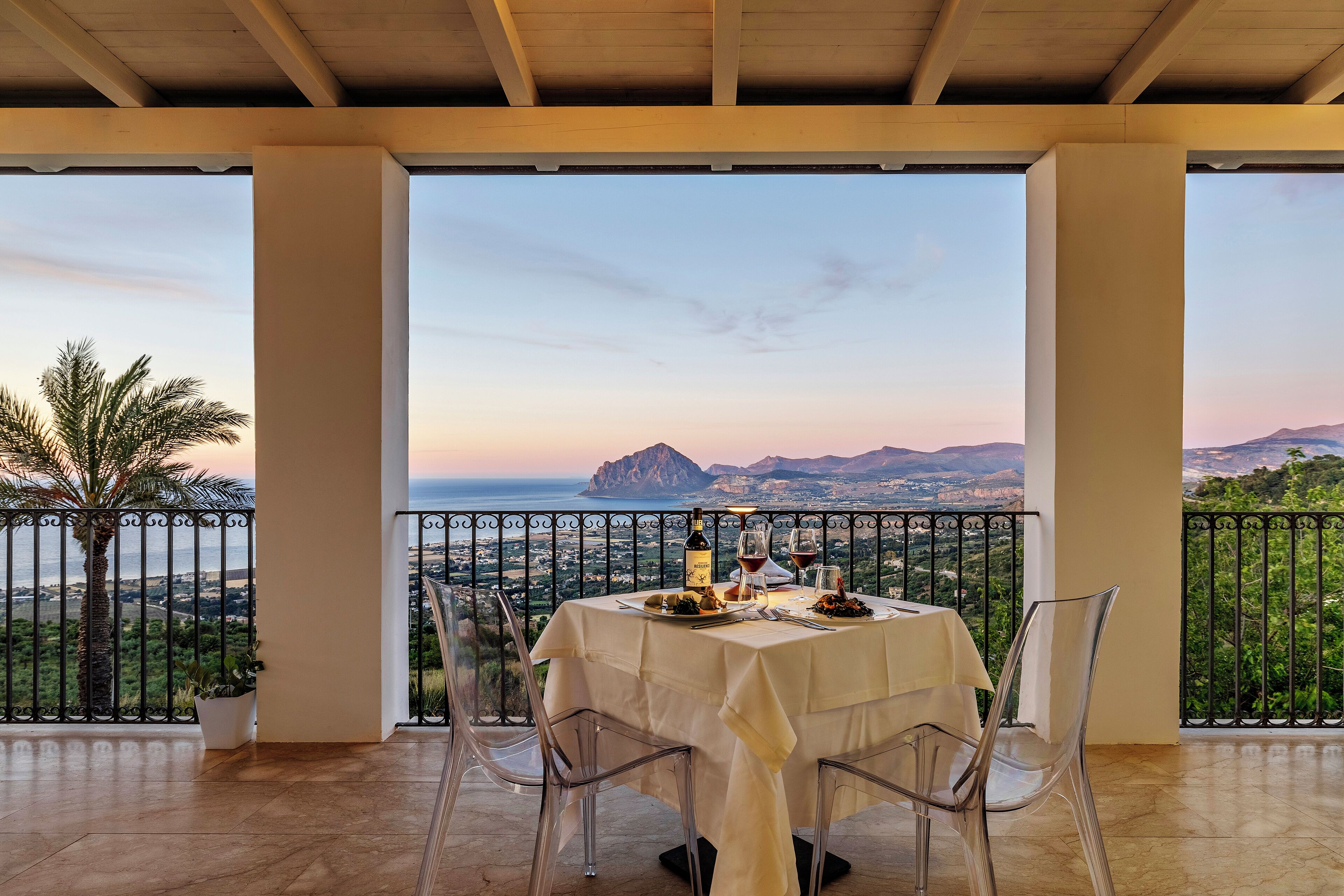 Un tavolo apparecchiato per due, con vista sul mare e sulle montagne.