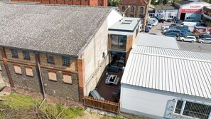 A multi-story building with a brick facade, a flat roof, and a small balcony. - LiT LiVING: LuxusLoft | Box SprIng | Air Con | BBQ (Mannheim)