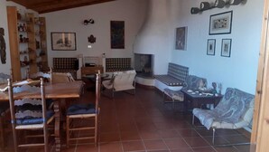 Ein gemütliches Wohnzimmer mit einem Holzesstisch, zwei Sofas und einem Kamin.